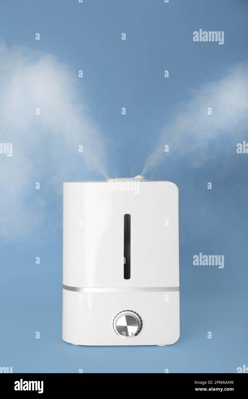 Modern air humidifier on light blue background Stock Photo - Alamy