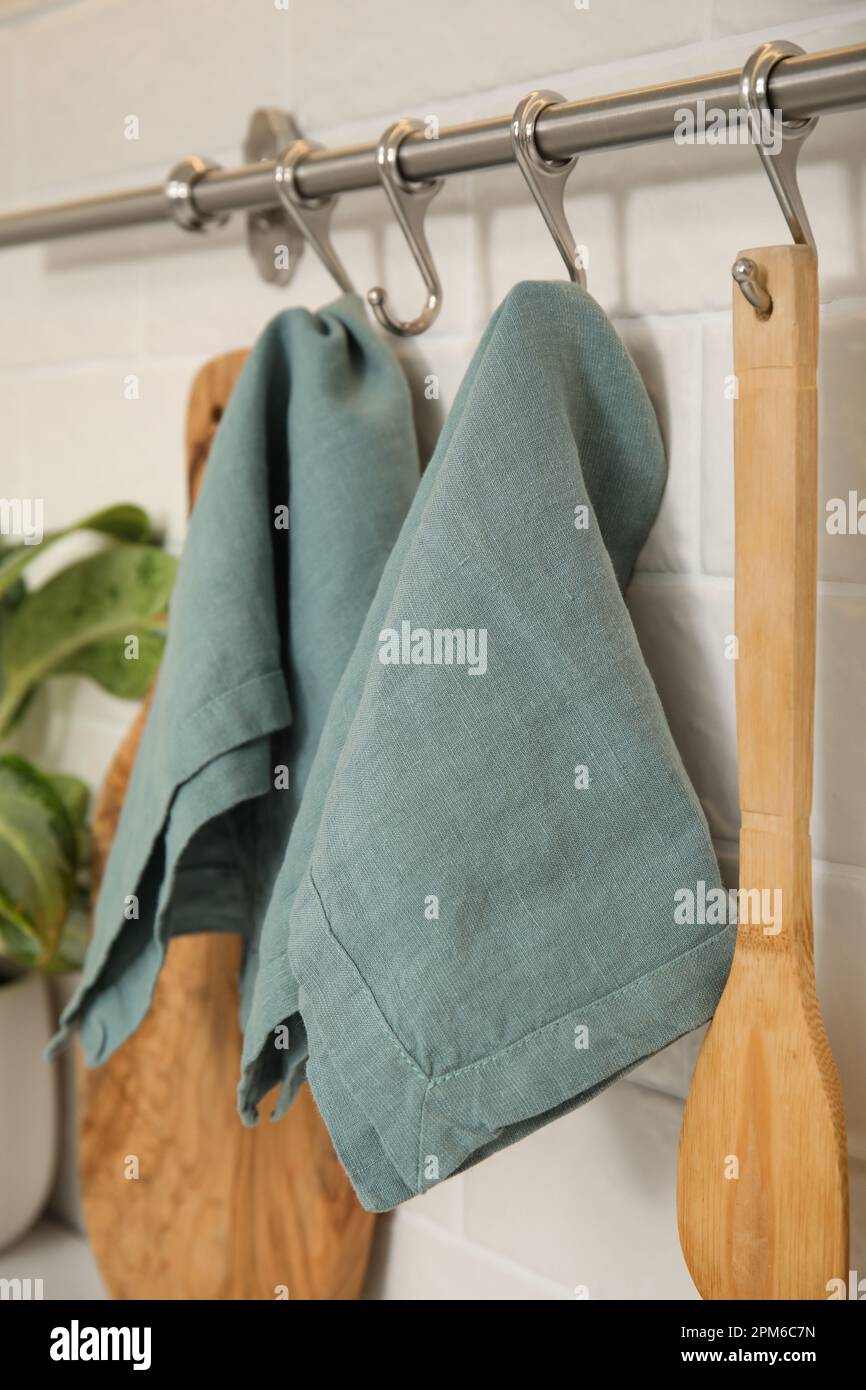 Clean towels and utensils hanging on rack in kitchen Stock Photo - Alamy