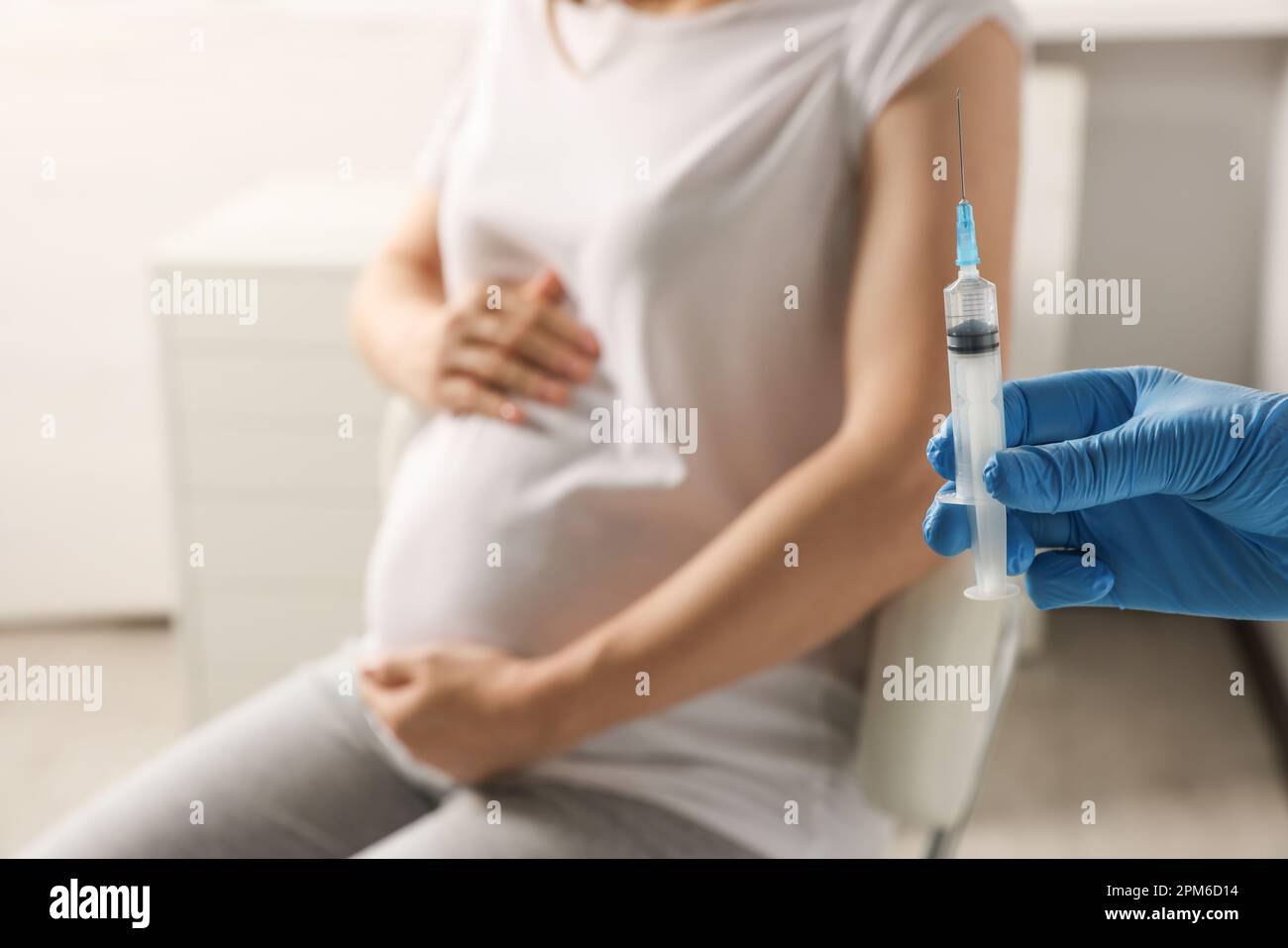 Doctor giving injection to pregnant woman in hospital, closeup Stock