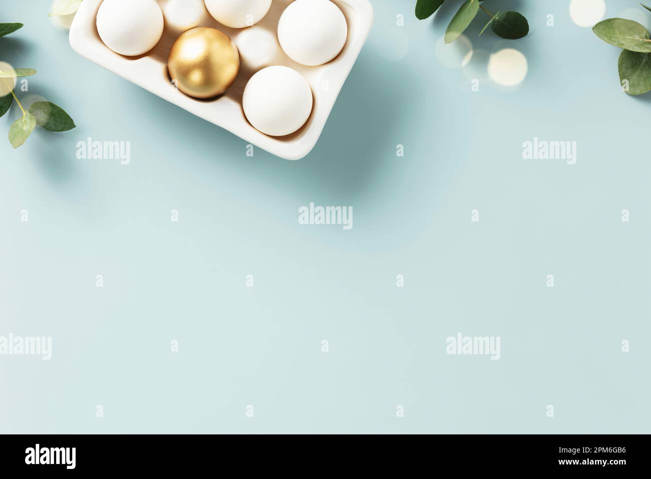Easter table decorations. Happy Easter concept with golden table setting, easter eggs, feathers and spring flowers. Easter background with copy space. Stock Photo