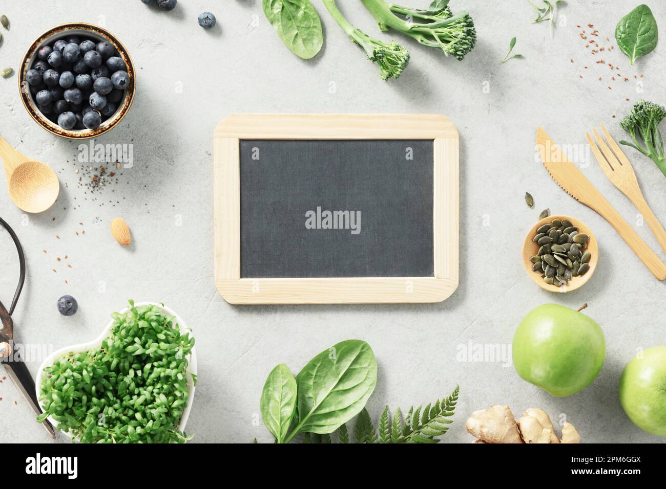 Vegetarian vegan healthy ingredients and empty chalk board on grey stone background. Healthy eating, eco friendly, zero waste concept Stock Photo