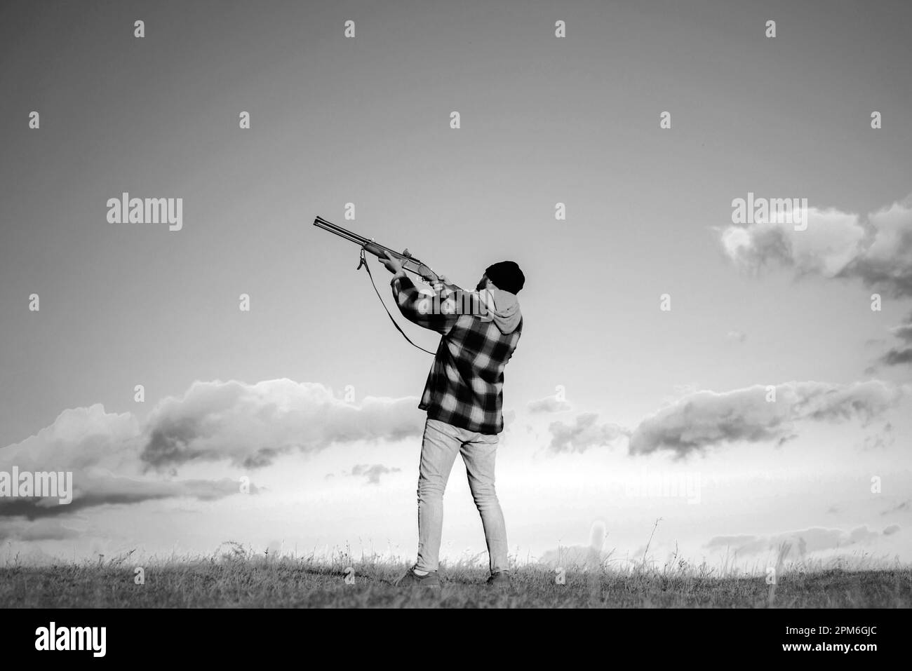 Skeet shooting. Hunter aiming rifle in forest. Hunter with shotgun gun