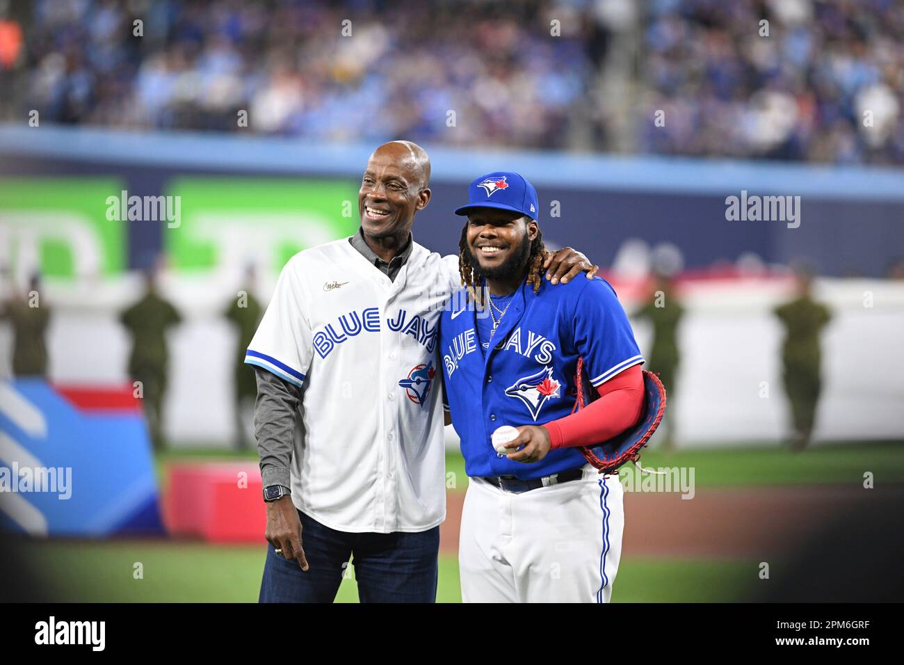 TORONTO, ON - APRIL 11: Toronto Blue Jays first baseman Vladimir Guerrero  Jr. (27) poses for the cameras after the opening ceremony pitch from Former Blue  Jays first baseman and recent Hall