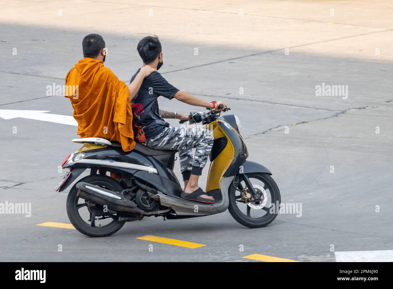A man rides a motorcycle with a Buddhist monk, Thailand Stock Photo