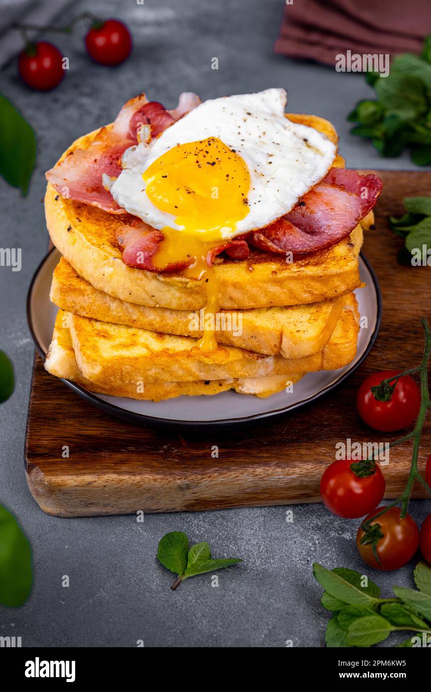 A Stack Of Eggy Bread Slices Topped With Fried Bacon And Egg Egg Yolk A Stack Of Eggy Bread Slices Topped With Fried Bacon And Egg Egg Yolk