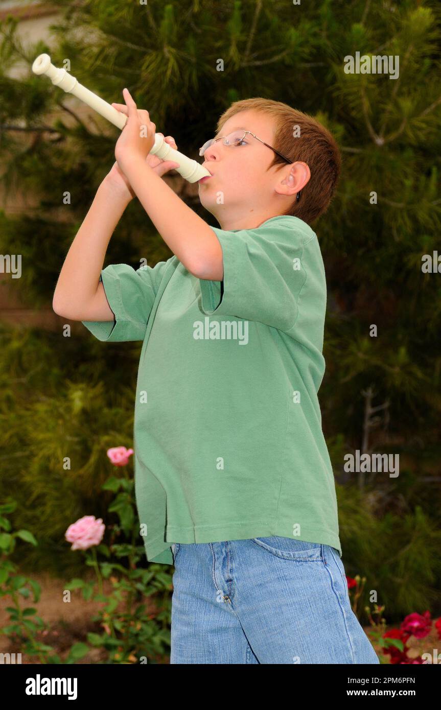 Young boy playing a recorder musical instrument Stock Photo Alamy