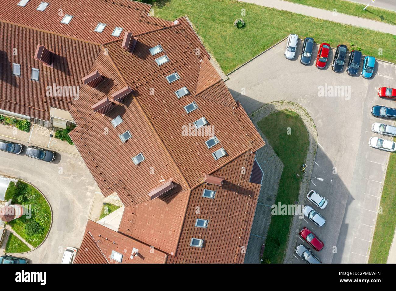 aerial view of residential houses with red roofs in quiet suburbs and street with parked cars. Stock Photo