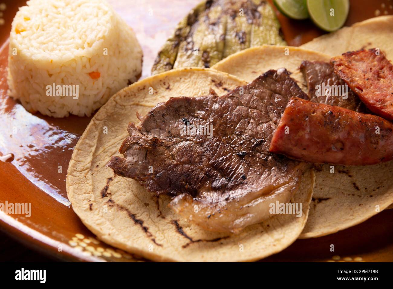 Roast meat (carne asada) very popular dish in northern Mexico, also called Asado, Discada or Parrillada, is a cooking technique in which food is expos Stock Photo