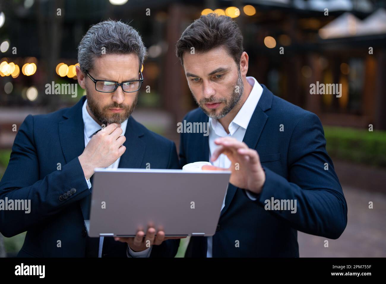 Business men team using laptop outdoor. Businessmen looking laptop with ...