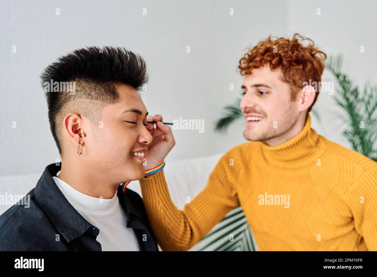 Gay man applying make up his couple at home Stock Photo