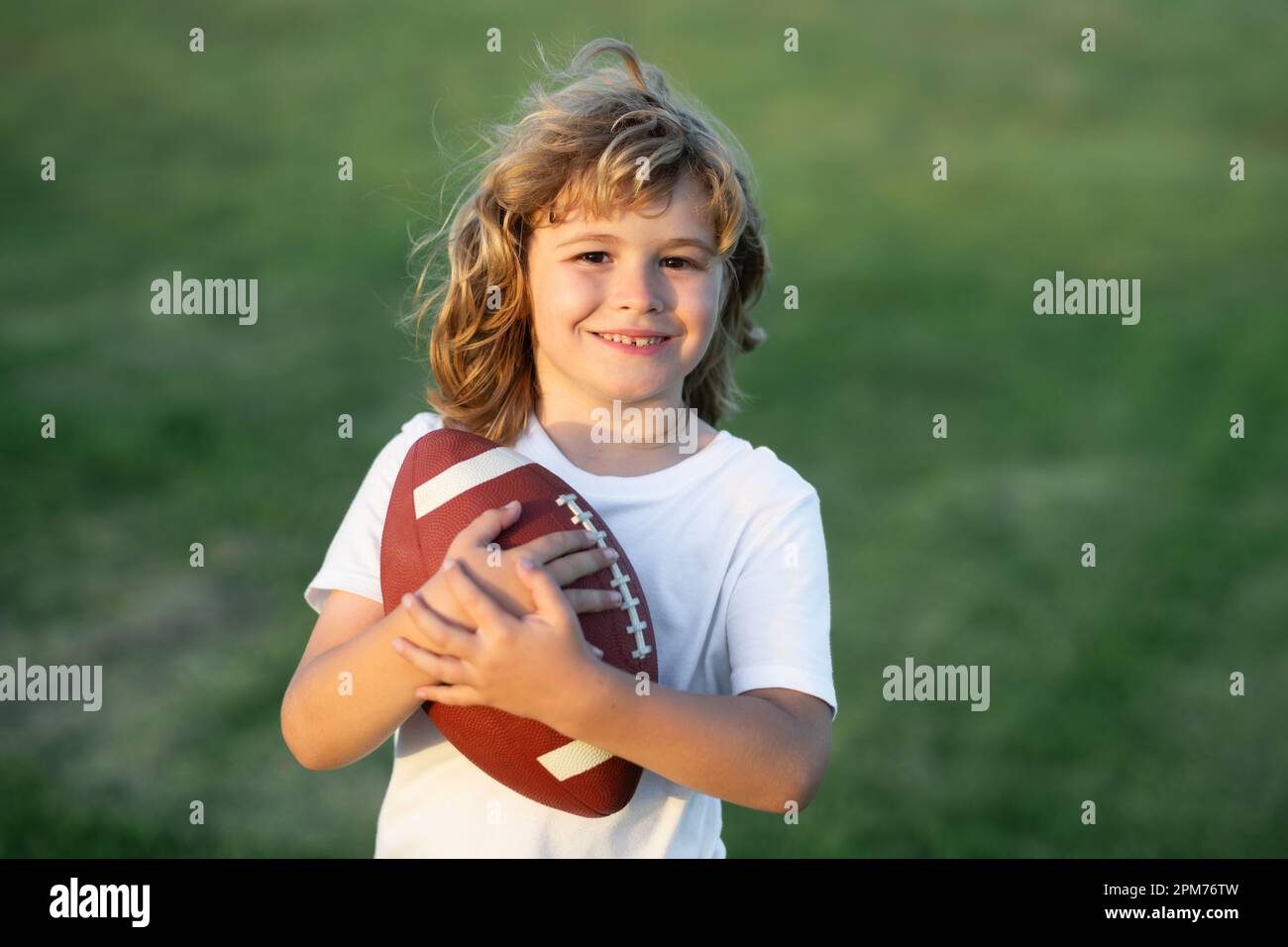 Kid boy playing with rugby ball in park. Football game, rugby, american ...