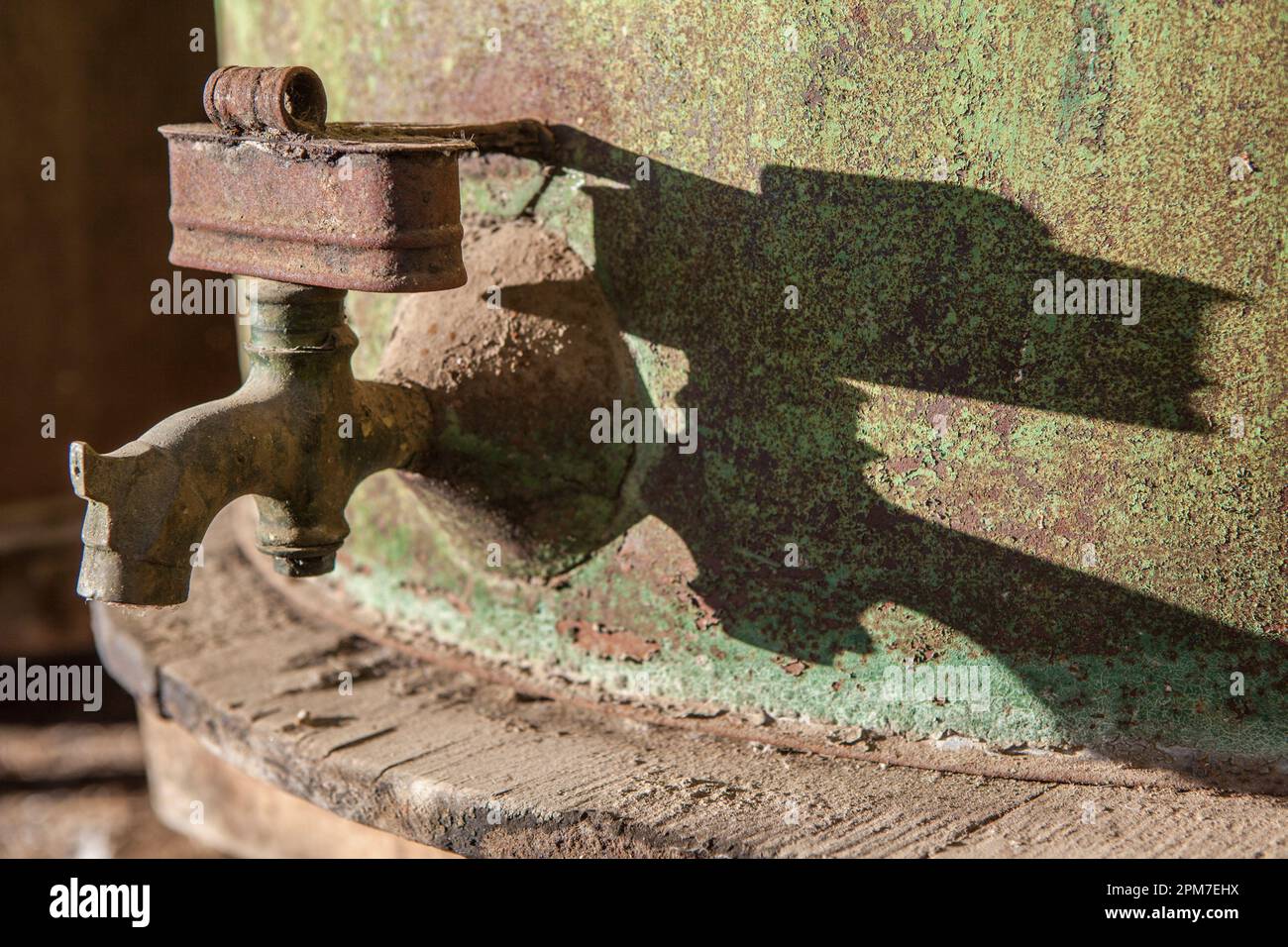 Rusty faucet detail from old olive oil drum. Old farm background. Stock Photo