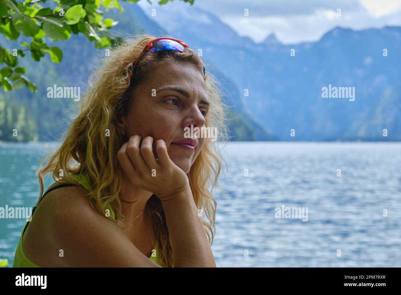 Side profile of a contemplative woman at the shore of lake Konigssee, Bavaria, Germany. Mood, portrait, nature, outdoor, meditation, introspection, me Stock Photo