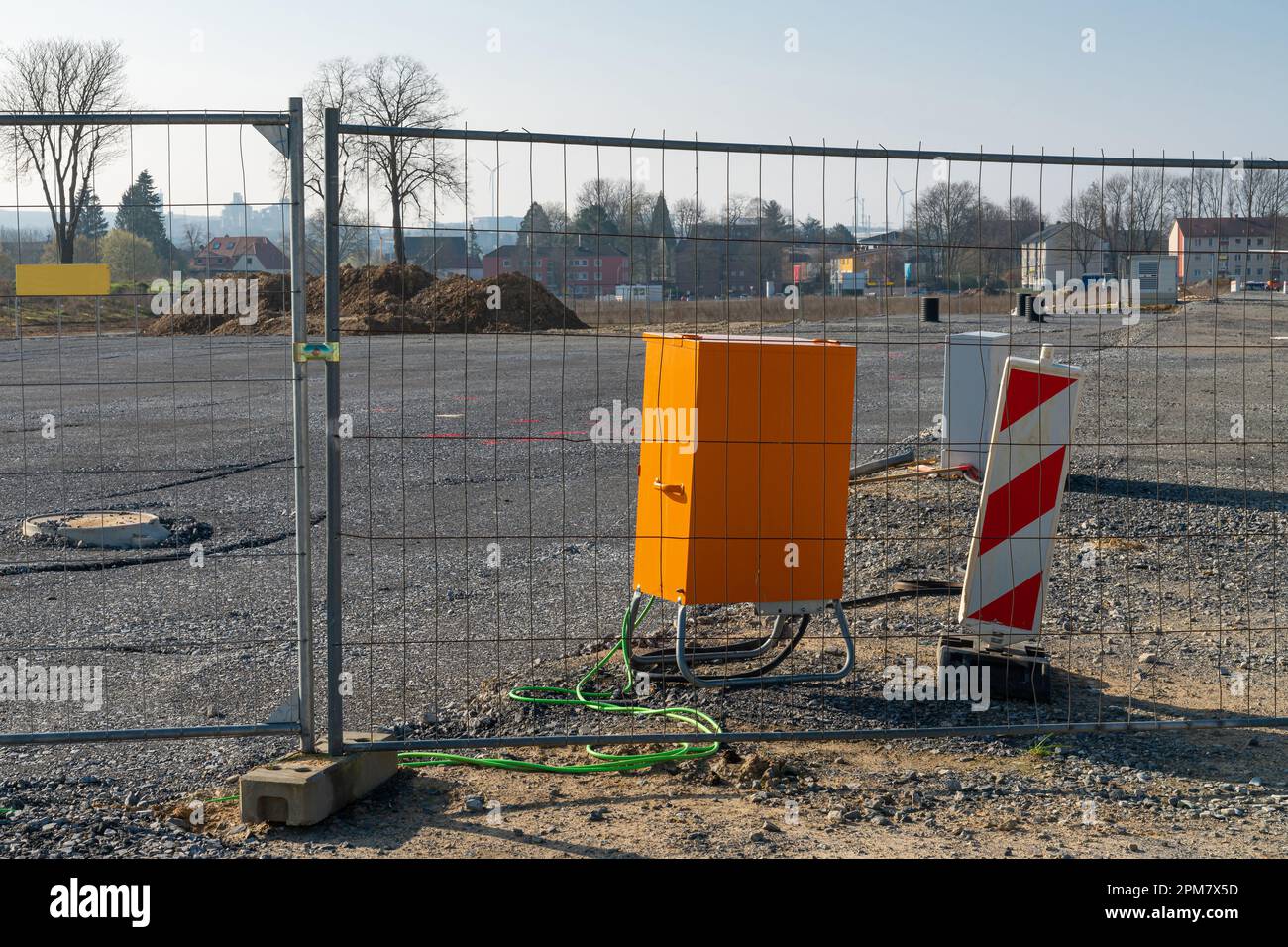 Electrical junction box in bright orange at a construction site behind a metal grid Stock Photo