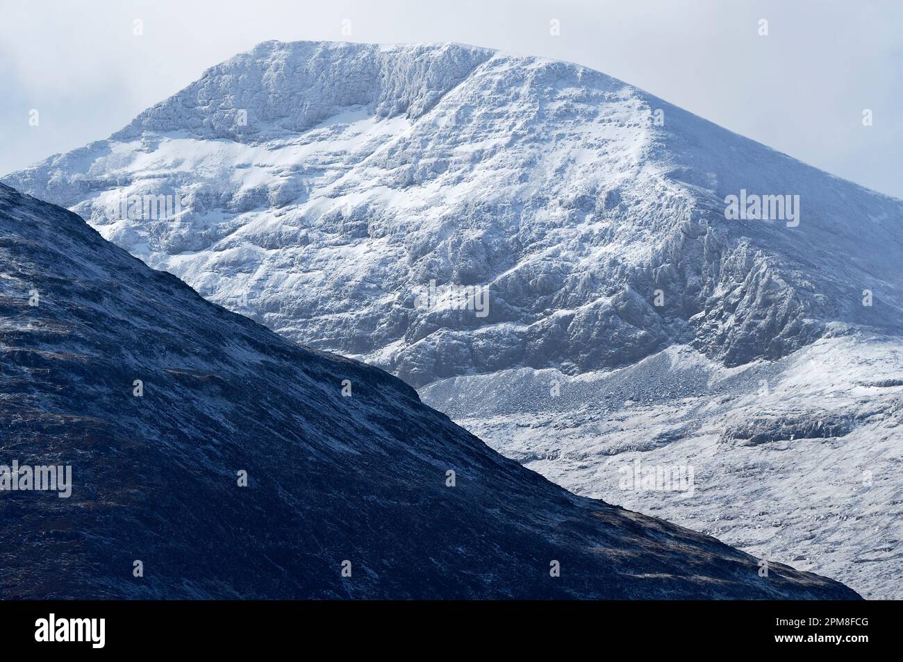 View of snow-capped mountain Ben More. At an elevation of 966m it is the highest mountain and only Munro on the Isle of Mull. Stock Photo