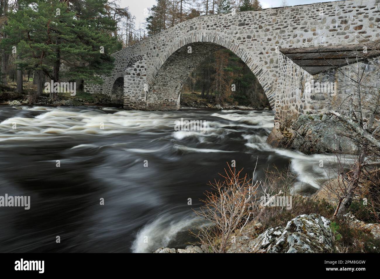 Old Bridge of Dee, also known as the Auld Brig O' Dee, original masonry road bridge crossing the river Dee at Invercauld Estate by Braemar, Cairngorms Stock Photo