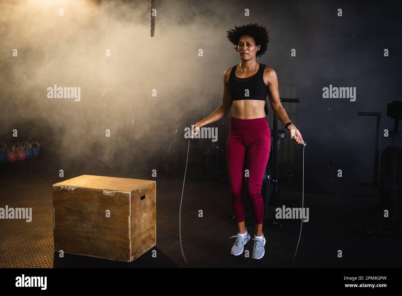 Full length of determined biracial young woman with afro hair skipping ...