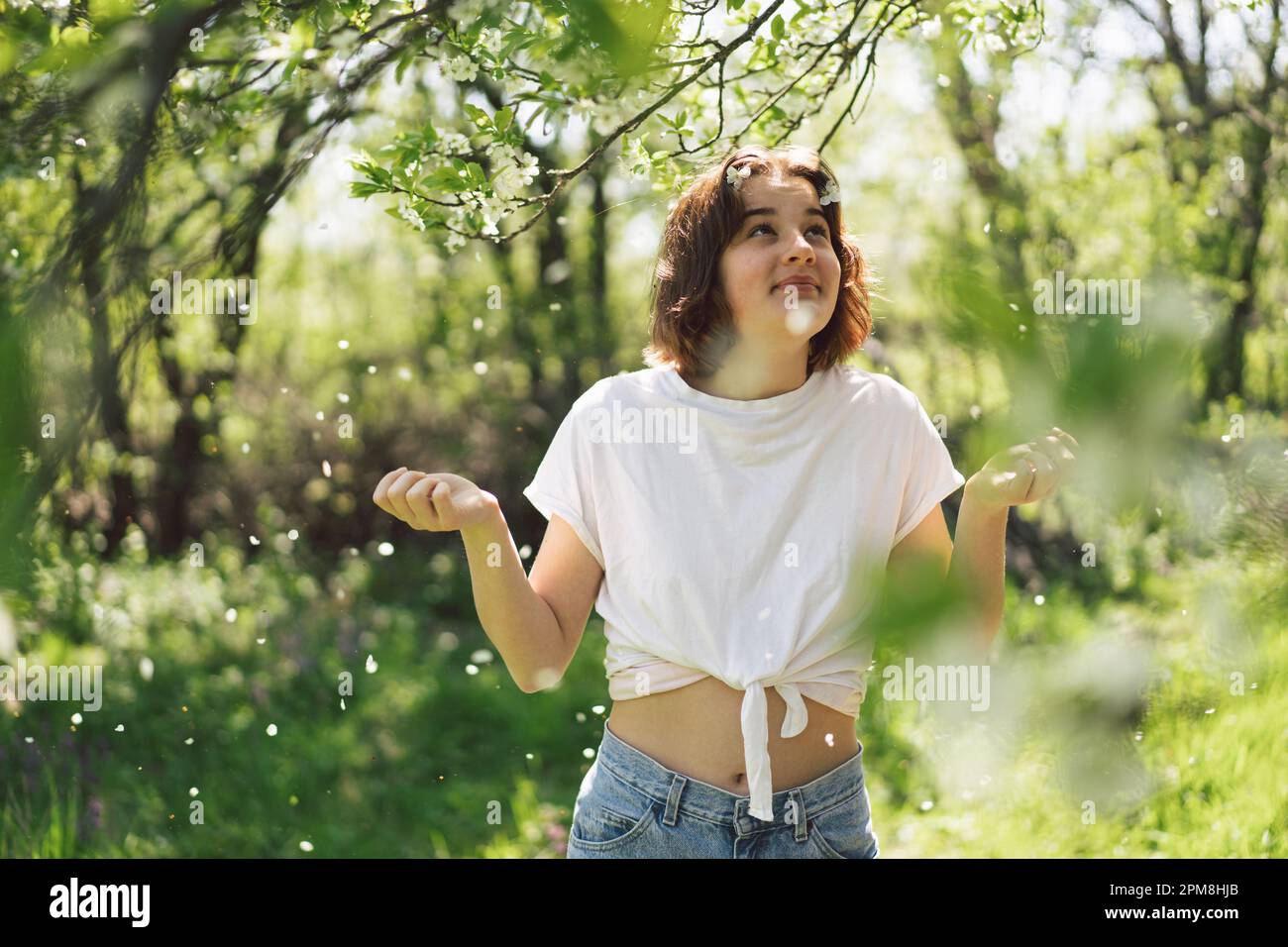 Spring Girl Beautiful teenage girl with spring flowers enjoying nature and laughing ...