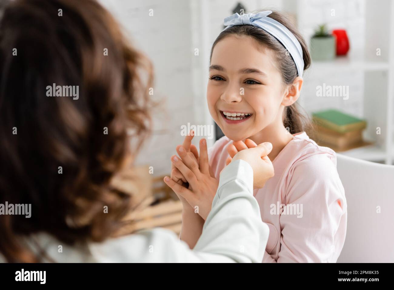 Blurred speech therapist working with cheerful pupil in consulting room,stock image Stock Photo