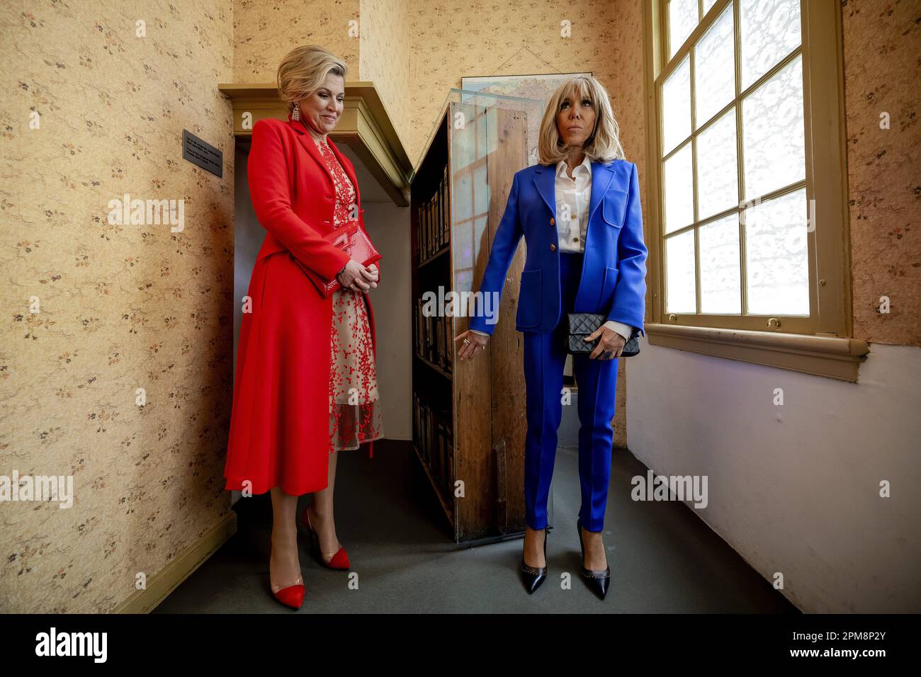 Amsterdam, Netherlands. 12th April, 2023. AMSTERDAM - The French first lady Brigitte Macron (r) and Queen Maxima at the bookcase that leads to the Secret Annex during a visit to the Anne Frank House. The French presidential couple is paying a two-day state visit to the Netherlands. ANP POOL ROBIN VAN LONKHUIJSEN netherlands out - belgium out Credit: ANP/Alamy Live News Credit: ANP/Alamy Live News Stock Photo