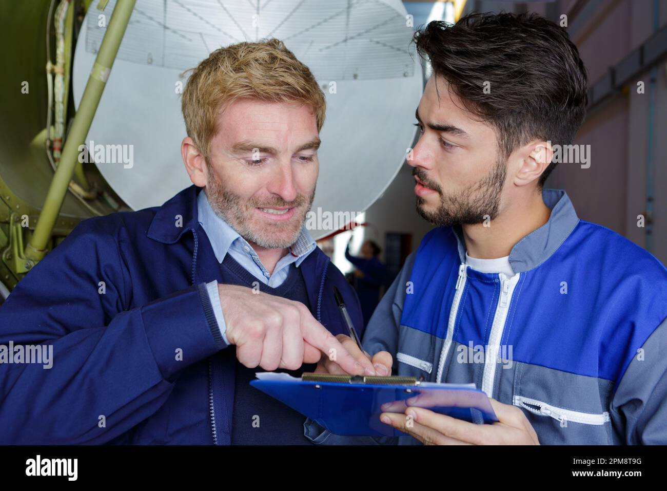 two aircraft assembling workers checking notes Stock Photo - Alamy