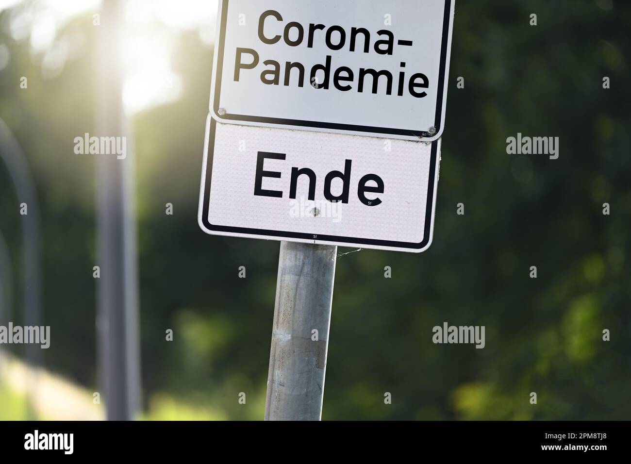 FOTOMONTAGE, Schild mit Aufschrift Corona-Pandemie und Schild mit Aufschrift Ende, Symbolfoto Ende der Corona-Pandemie Stock Photo
