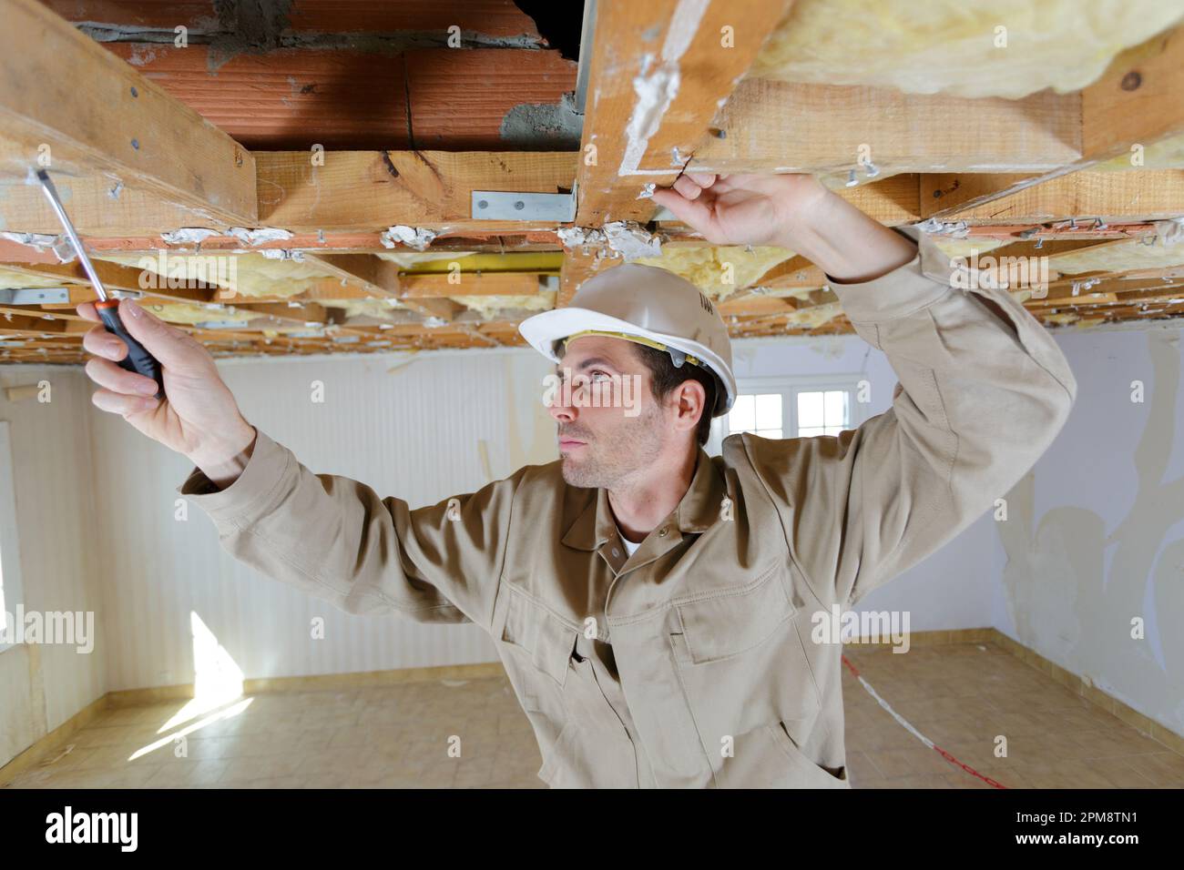 a male working on ceiling Stock Photo