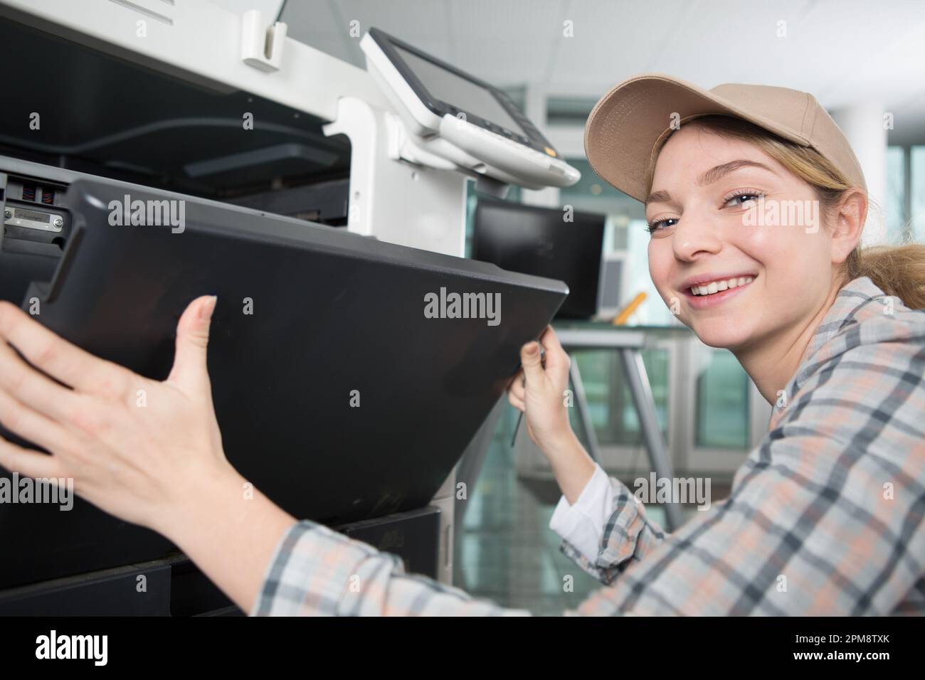young woman fixing a printer Stock Photo
