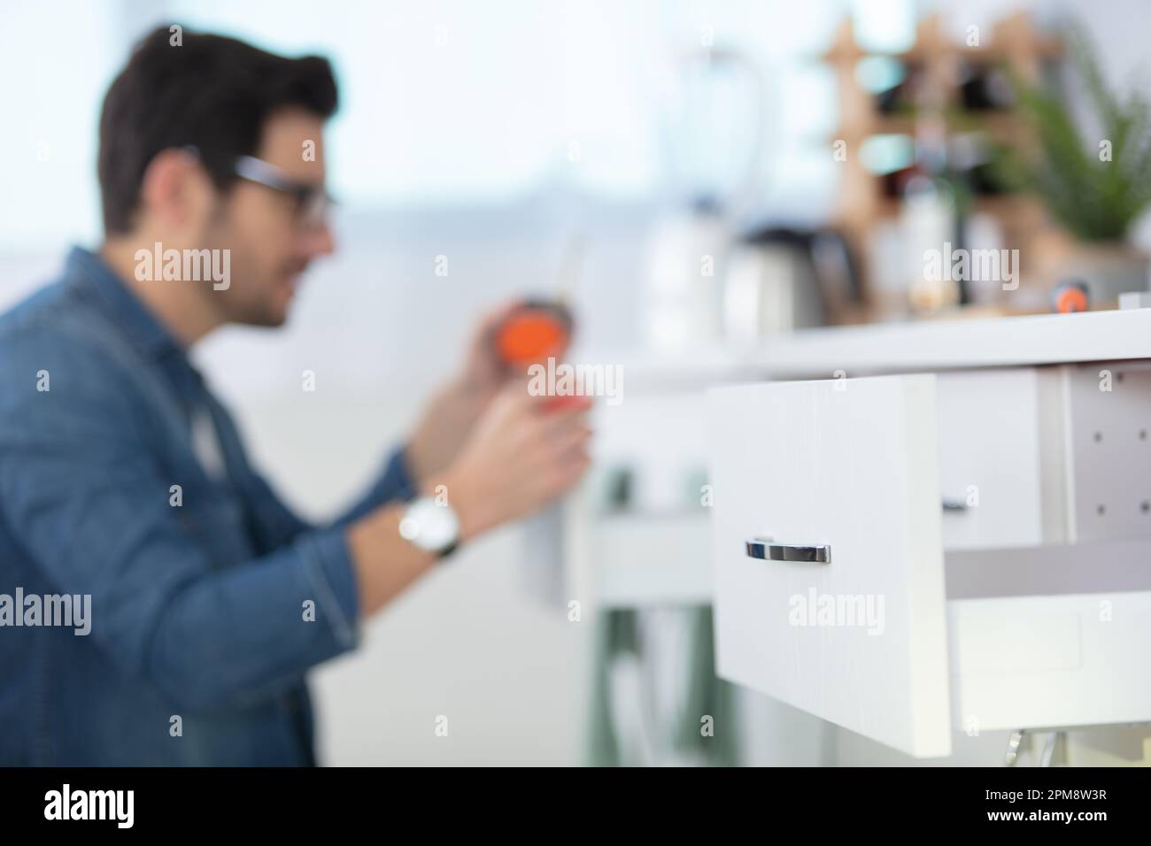 carpenter working on new kitchen cabinets Stock Photo
