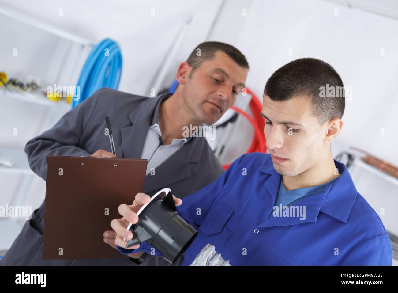 mechanic and apprentice working on car with computer Stock Photo - Alamy