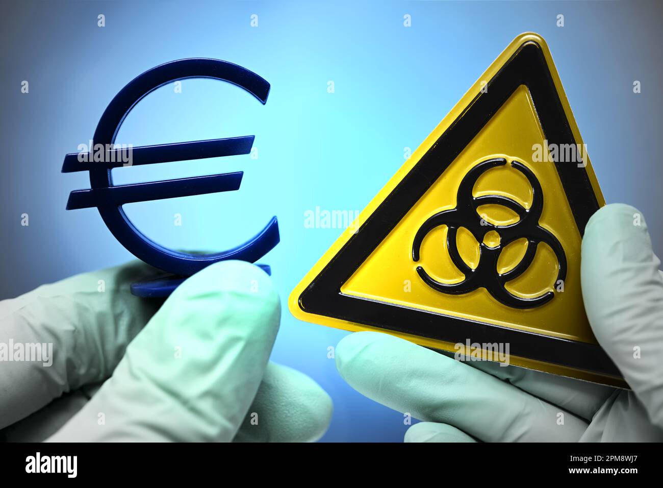 Hände in Latexhandschuhen halten Eurozeichen und Biogefährdungszeichen, Kosten der Corona-Pandemie Stock Photo