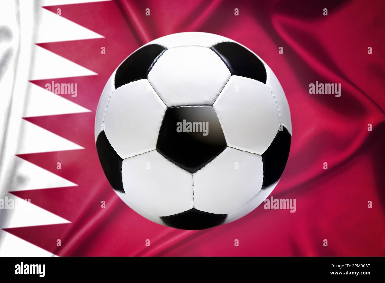 FOTOMONTAGE, Schwarz-weißer Fußball vor Fahne von Katar, Symbolfoto Fußballweltmeisterschaft Stock Photo