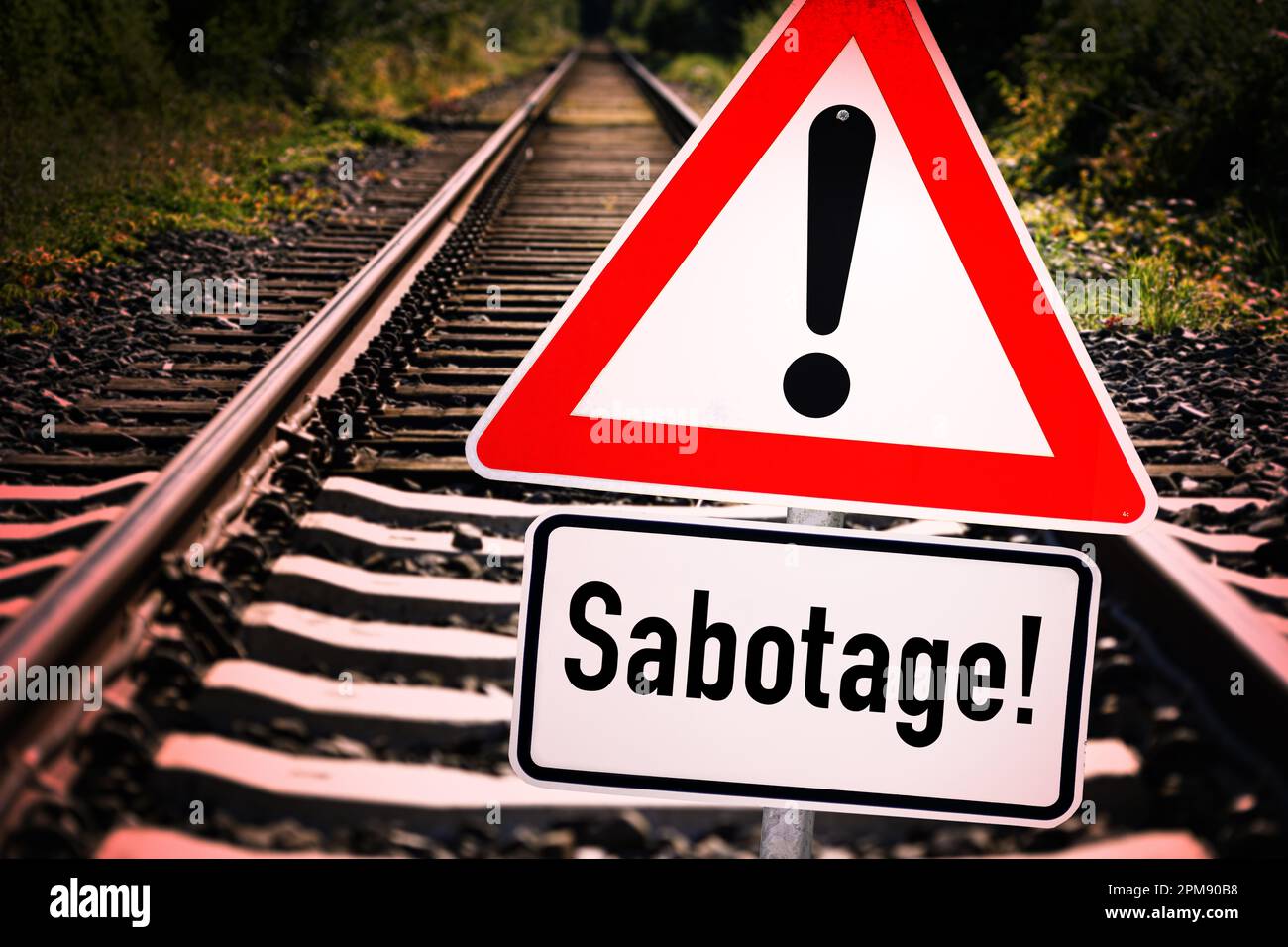 FOTOMONTAGE, Leere Bahngleise und Gefahrenschild mit der Aufschrift Sabotage Stock Photo