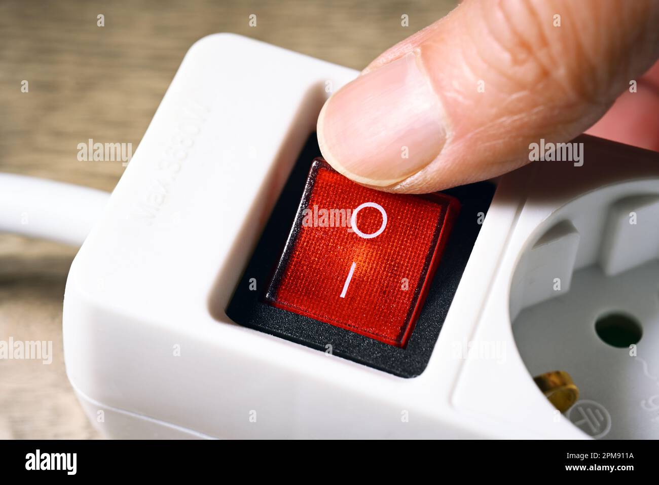 Finger schaltet Kippschalter an einer Steckdosenleiste aus, Symbolfoto Energiesparen Stock Photo