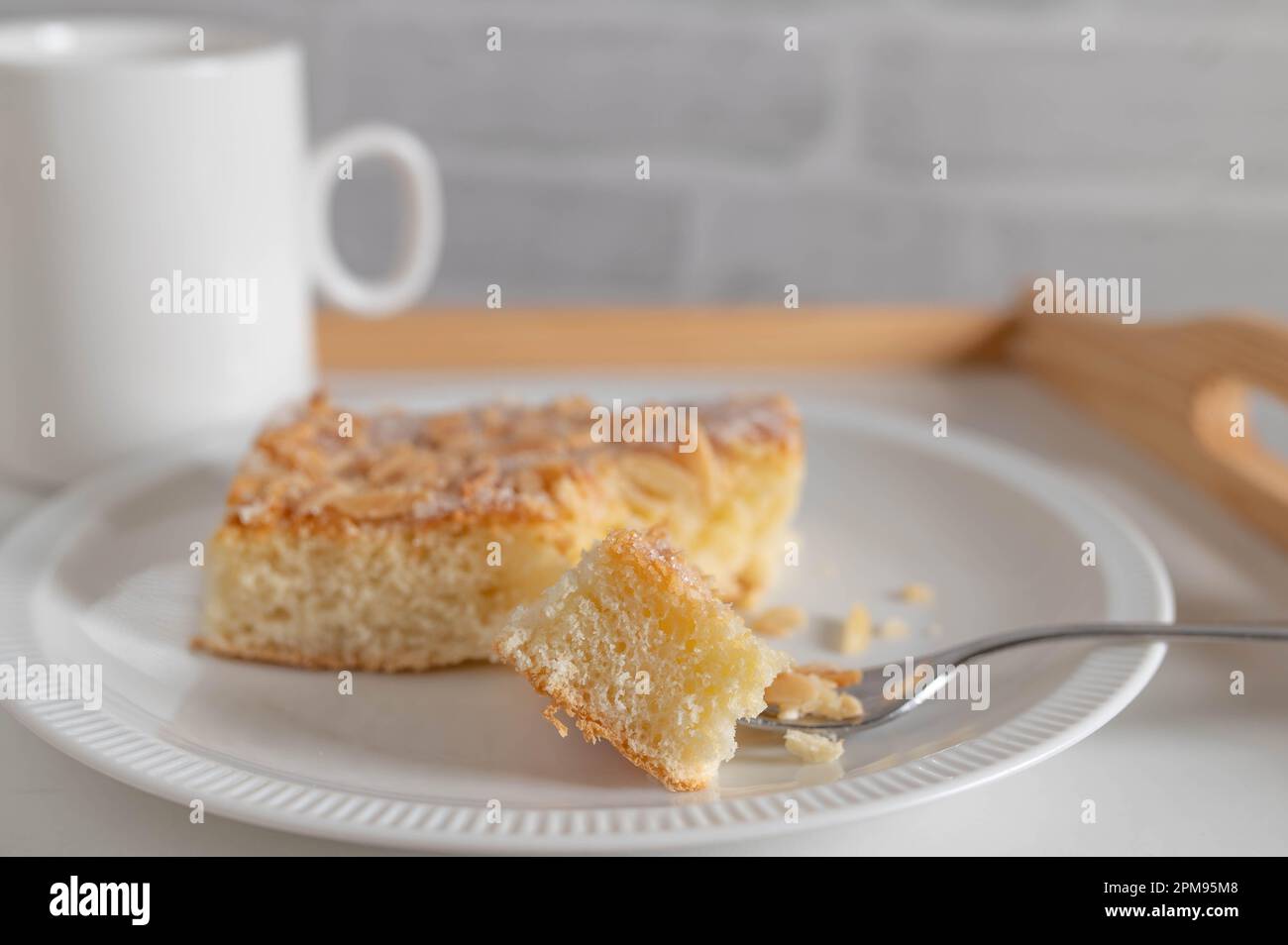 Butter cake with almond, sugar topping. Traditional german yeast cake served on a plate Stock Photo
