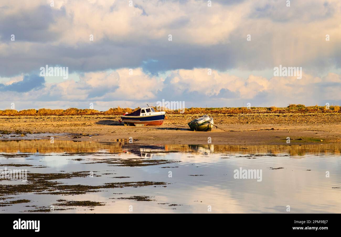 Grounded boats on sandbank with incoming tide in harbour at Red Wharf Bay (Traeth Coch), Benllech, Isle of Anglesey (Ynys Mon), Wales, UK, Britain Stock Photo