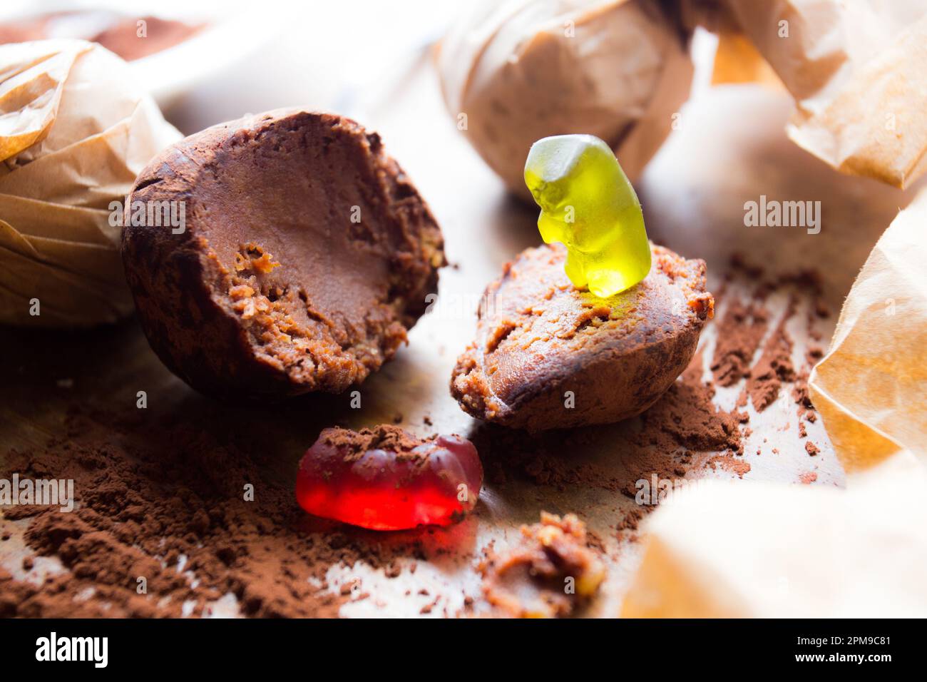 Gummy bears playing on a food table with a chocolate ball. Stock Photo