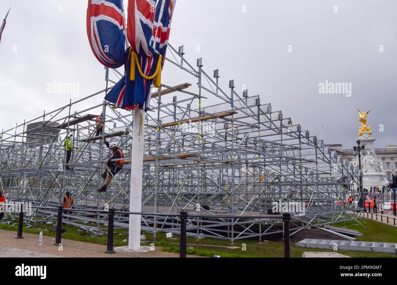 London, UK. 12th April 2023. Workers install seats outside Buckingham Palace as preparations for