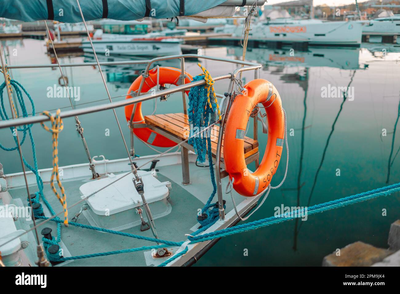 Orange lifebuoy or lifebelt emergency equipment device, hanging on ship deck wall. Unmarked