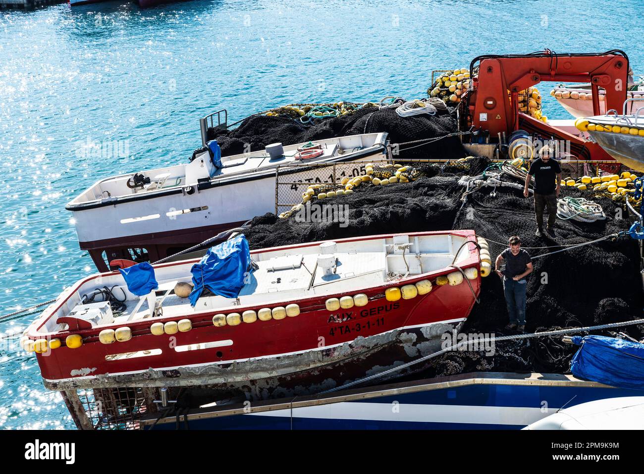 L Ametlla de Mar, Spain - May 11, 2022: Tuna purse seiner ship with workers docked in the port of Ametlla de Mar, Tarragona, Catalonia, Spain Stock Photo