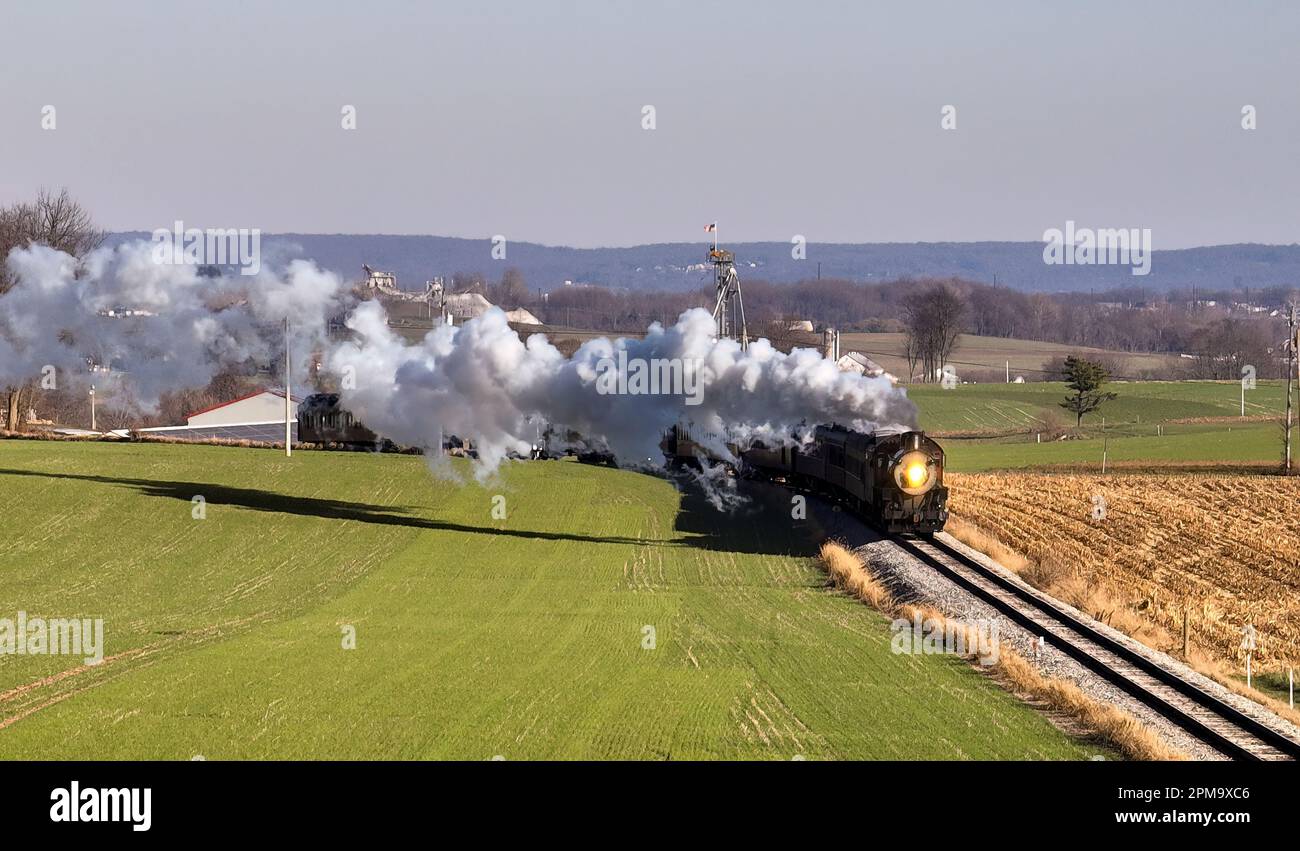 A vintage steam locomotive traveling along a set of railroad tracks ...