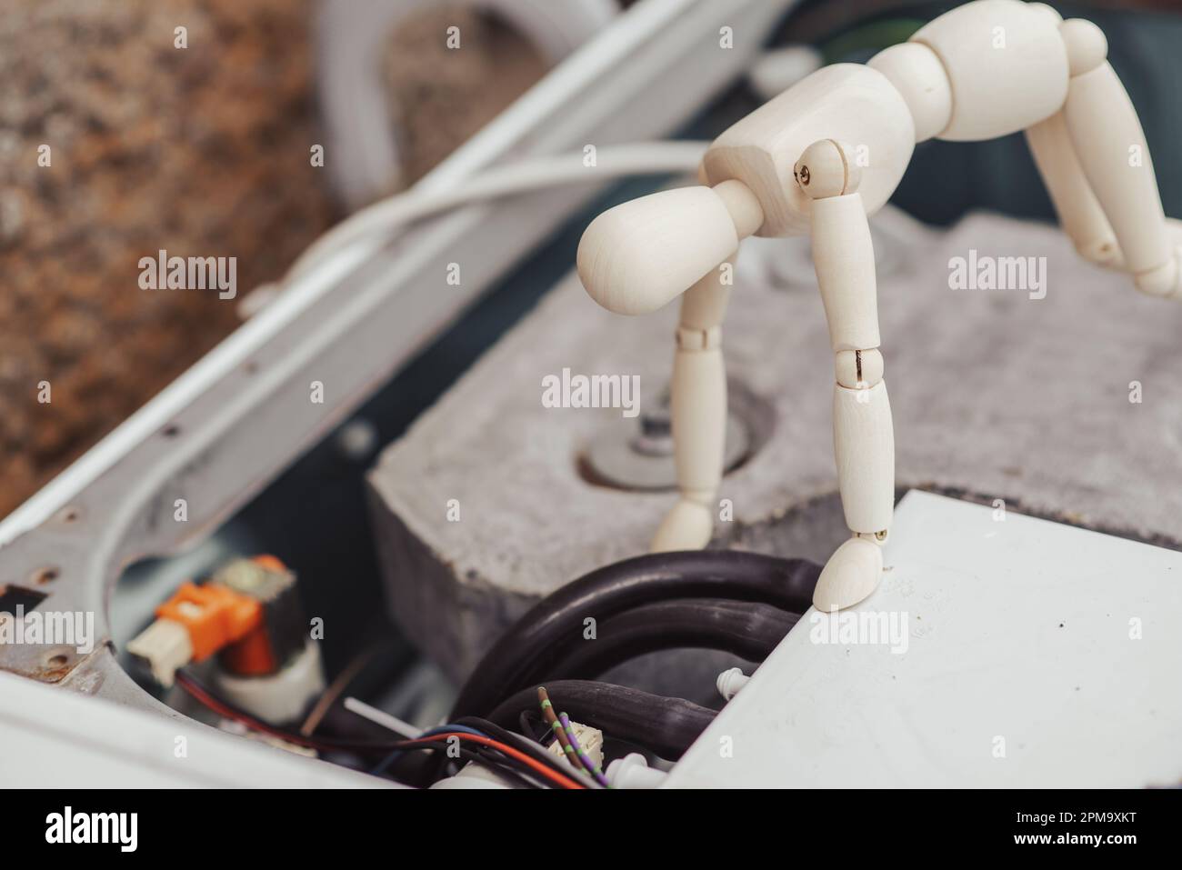 washing machine repair concept. A human figurine looks at the