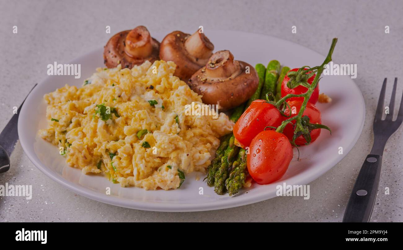 Healthy breakfast with scrambled eggs,mushrooms,tomatoes and asparagus