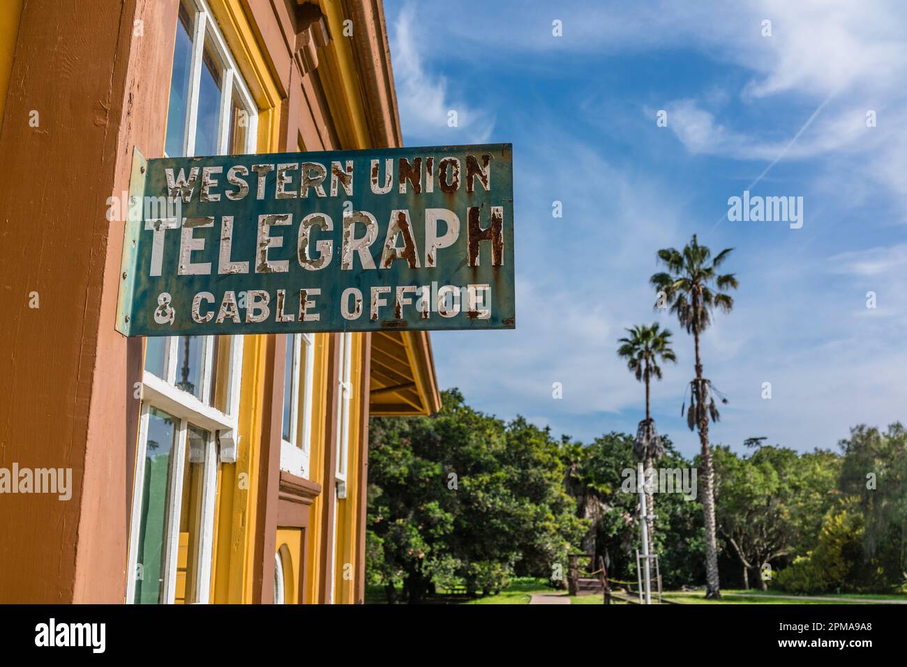 Western Union sign at Goleta,  CA  train station building with two palm trees in the background. Stock Photo