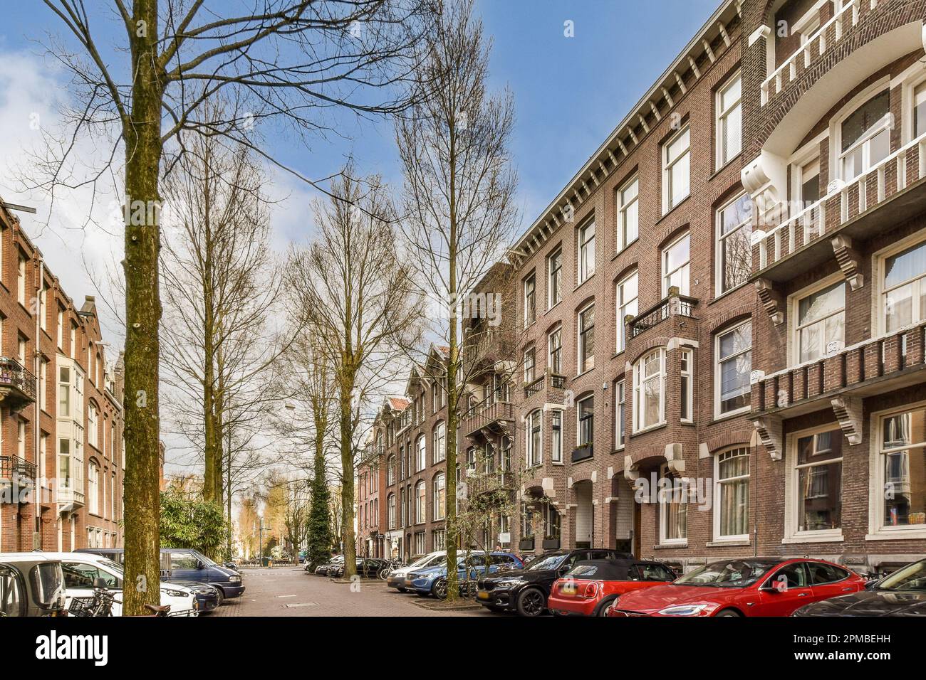 some cars parked on the side of a street in an urban area with tall ...