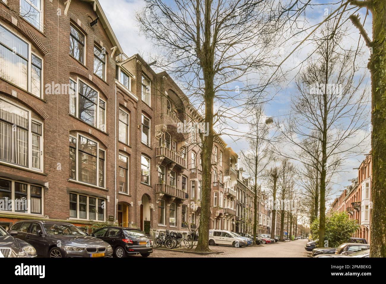 some cars parked on the side of a street in an urban area with tall ...