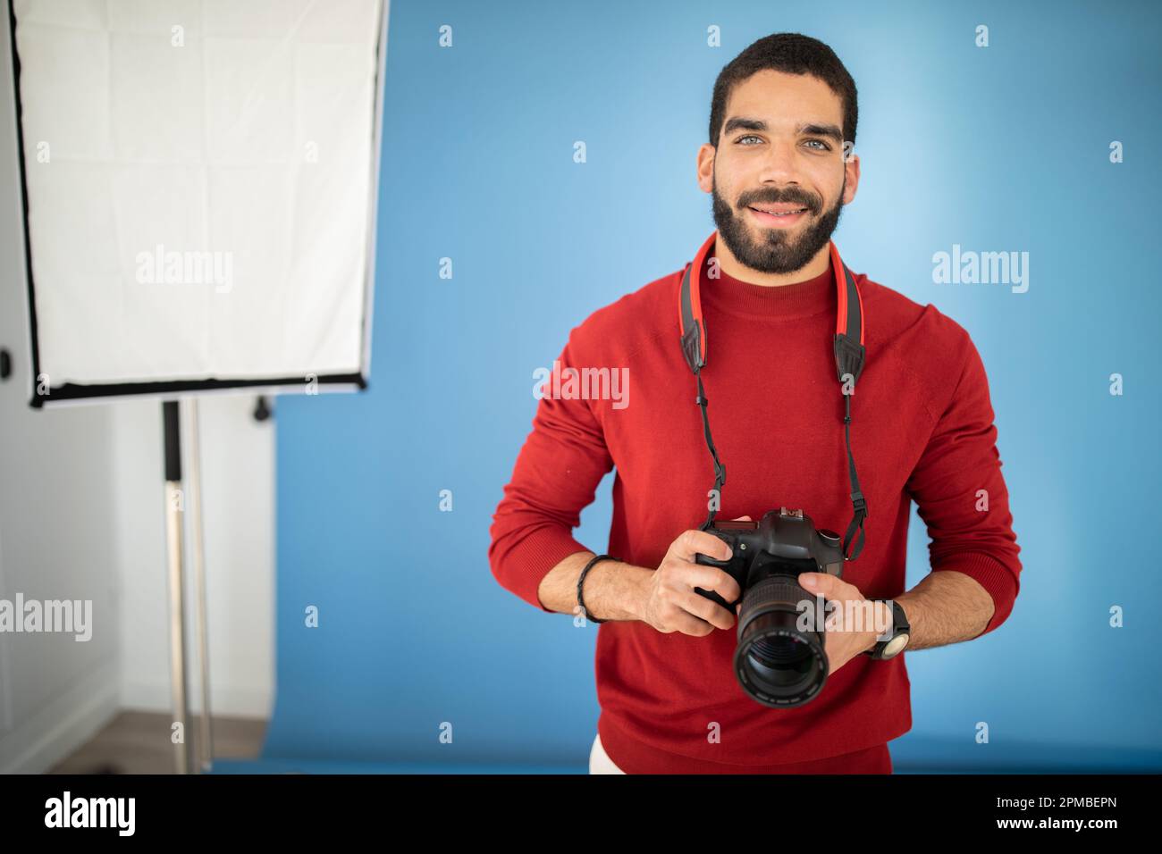 Happy handsome young guy professional photographer using digital camera Stock Photo