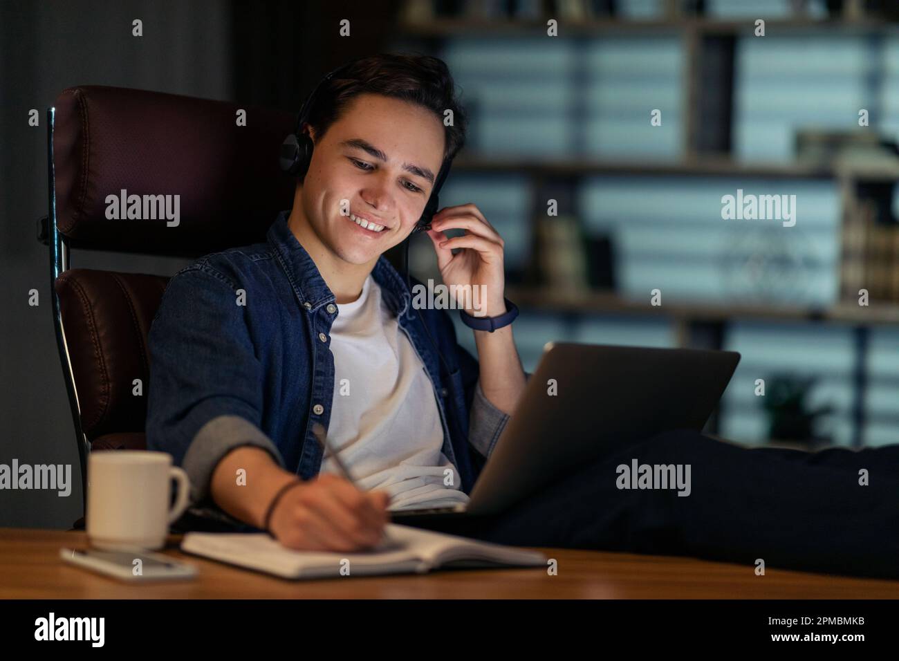 Cheerful young man employee working night shift at office Stock Photo