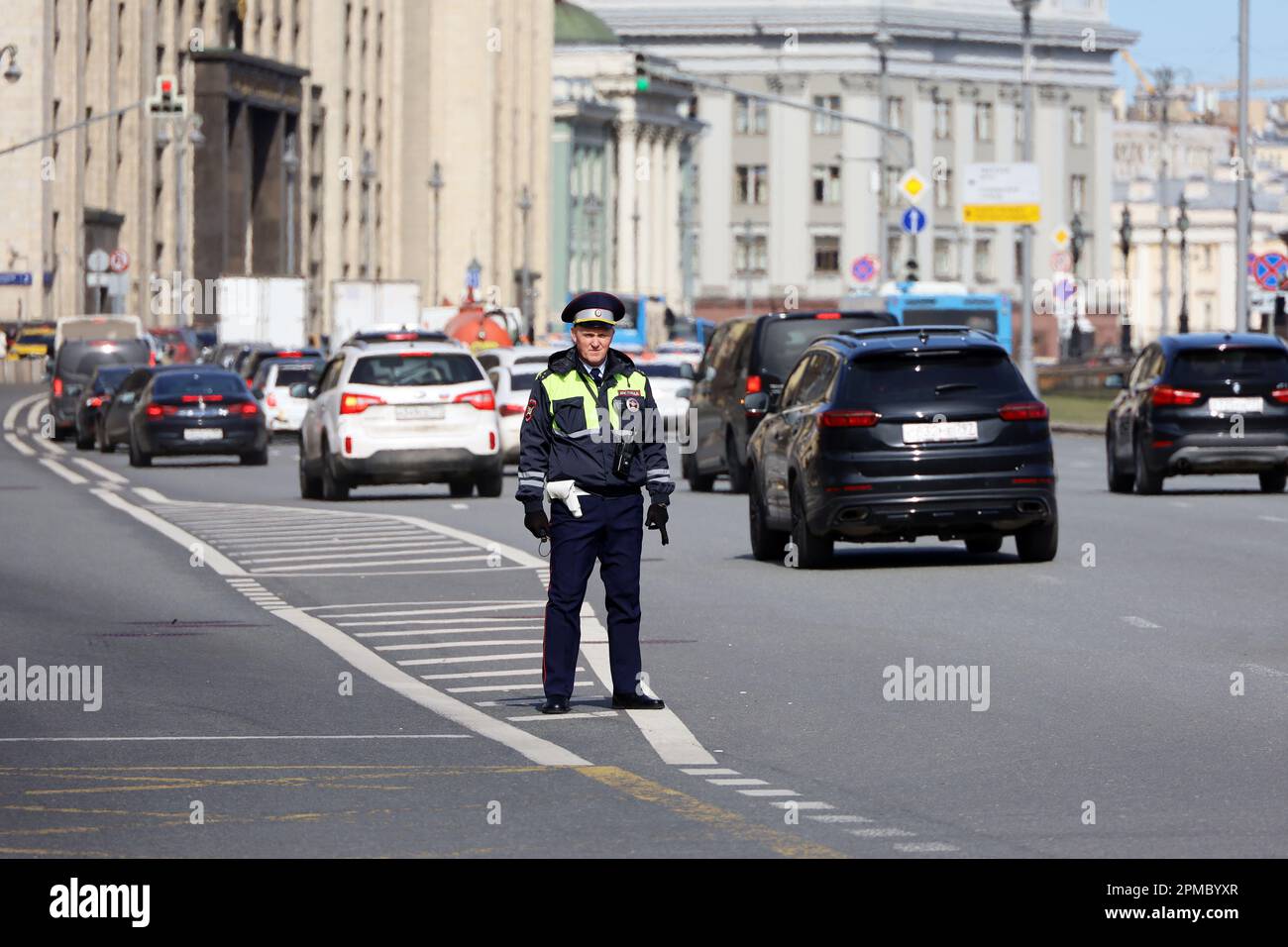 Traffic police officer standing against cars and State Duma building. Policeman patrol the city street in center Stock Photo