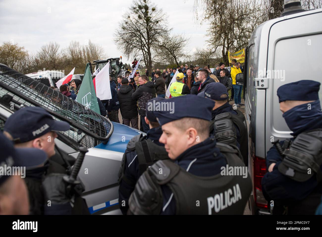 Protesting farmers are seen behind a police blockade at the broad-gauge railway line crossing in Hrubieszow border town. The police prevented the announced Wednesday morning protest of farmers from AgroUnia (AgroUnion) organization led by Michal Kolodziejczak, who were supposed to block the broad-gauge railway line in Hrubieszow border town, where grain from Ukraine enters Poland. As Michal Kolodziejczak said, the protest was reported for 7 days, but farmers are ready to extend it. (Photo by Attila Husejnow/SOPA Images/Sipa USA) Stock Photo